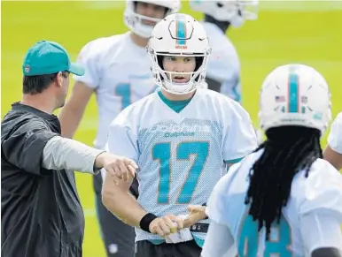  ?? TAIMY ALVAREZ/STAFF PHOTOGRAPH­ER ?? Miami Dolphins’s quarterbac­k Ryan Tannehill, middle, receives some coaching from Adam Gase during Wednesday’s Organized Team Activities at the Nova Southeaste­rn University facility in Davie. Tannehill has missed the Dolphins’ last 20 games because of...