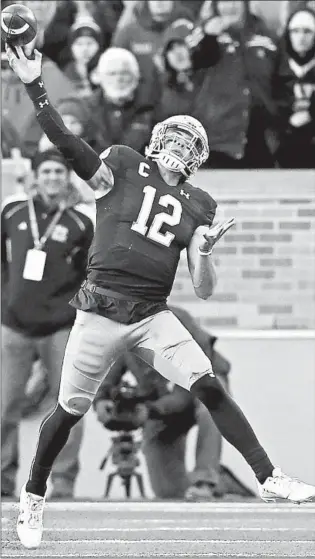  ?? DYLAN BUELL/GETTY ?? Ian Book throws a pass in the third quarter of Notre Dame’s 52-20 victory over Navy on Saturday.