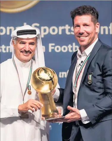  ??  ?? NOTABLE. Simeone, recibiendo el premio de Saeed Hareb, secretario general del Consejo de Deportes.