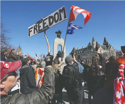  ?? DAVE CHAN/AFP ?? Protesters wave flags and signs on Saturday in front of the National War Memorial in Ottawa during a “Rolling Thunder” rally, convened two months after a trucker-led occupation of Canada's capital.