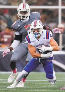  ?? Matthew J. Lee / Boston Globe 2016 ?? Louisiana Tech’s Trent Taylor, who ranks fifth on Division I college football’s career catches list, eludes UMass’ Kyle Horn.