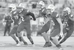  ?? MICHAEL LAUGHLIN/SUN SENTINEL ?? Stoneman Douglas’ Jaydin Fernandez (2) runs with his team toward the Monarch defense during the first half of their game Thursday night in Parkland.