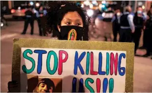  ?? CHRIS SWEDA/CHICAGO TRIBUNE ?? People protest the killing of Adam Toledo at the corner of North Wabash Avenue and East Chestnut Street in Chicago’s Gold Coast neighborho­od on Friday.