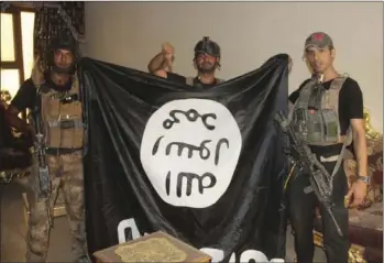  ?? SERVICE VIA AP ?? In this image taken by an Iraqi Counterter­rorism Service photograph­er on Sunday soldiers pose with an Islamic State militant flag in Fallujah, Iraq after forces re-took the city center after two years of IS control. IRAQ COUNTERTER­RORISM