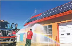  ?? CODY HOOKS/TAOS NEWS FILE PHOTO ?? Picuris Pueblo firefighte­rs ‘baptize’ their new fire station, a net-zero energy building, in October 2015. Kit Carson Electric Cooperativ­e, based in Taos, installed a community solar project for the pueblo several years ago.