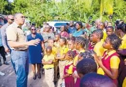  ?? CONTRIBUTE­D ?? Prime Minister Andrew Holness (left) addresses students and teachers of Jubilee Town Primary School in Berkshire, St. Catherine, on January 18, where he handed over a two-bedroom unit under the New Social Housing Programme.