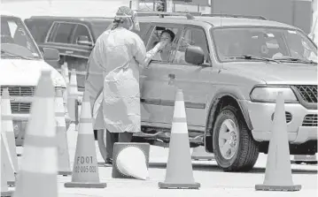  ?? MIKE STOCKER/SOUTH FLORIDA SUN SENTINEL ?? Health care workers administer free drive-thru COVID-19 tests Wednesday at the Hard Rock Stadium in Miami Gardens.