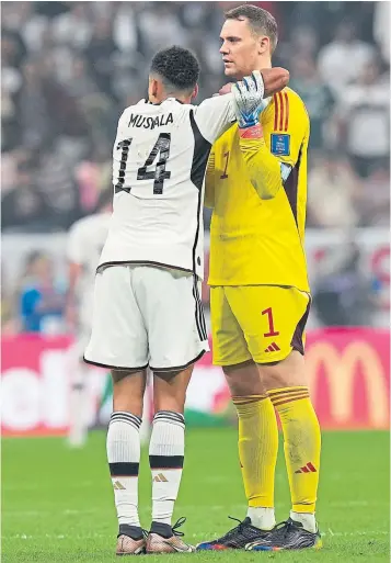  ?? ?? Manuel Neuer consoles Jamal Musiala after Germany’s early exit in Qatar. For the Bayern Munich keeper, things just got worse