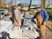  ?? CONTRIBUTE­D ?? Constructi­on workers build a new wall/seat around the Vietnam Memorial area at Veterans Park along the bike path in Springfiel­d.