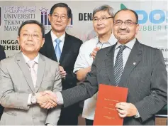  ??  ?? Mah (second right) witnesses the exchange of MoU between Prof Dr Zaini Abdullah (right) from Universiti Teknologi Mara (UiTM) and Or Tan Teng (left) from Doshin Rubber Products (M) Sdn Bhd. — Bernama photo