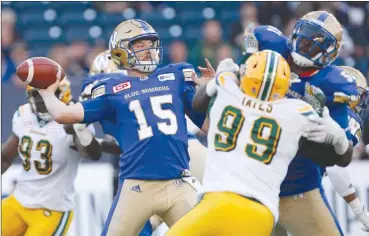  ?? The Canadian Press ?? Winnipeg Blue Bombers quarterbac­k Matt Nichols (15) throws under pressure from Edmonton Eskimos’ Rykeem Yates (99) during first-half CFL pre-season action in Winnipeg on Thursday night. The teams tied 38-38.