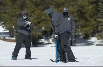  ?? RANDALL BENTON — THE ASSOCIATED PRESS ?? Assisted by Ramesh Gautam, left, and Anthony Burdock right, Sean de Guzman, chief of snow surveys for the California Department of Water Resources, checks the depth of the snowpack during the second snow survey of the season at Phillips Station near Echo Summit on Tuesday.