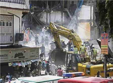  ??  ?? Dire situation: Rescue workers clearing debris at the site of the collapsed building in Mumbai. — AP