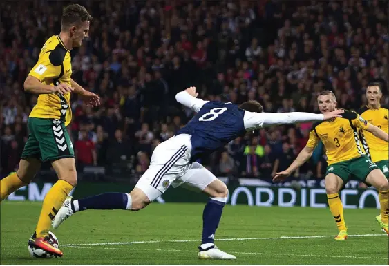  ??  ?? NOT THIS TIME: Scotland forward Oliver Burke goes tumbling in the penalty box under a first-half challenge from Edvinas Girdvainis but the ref wasn’t interested