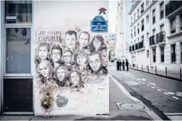  ?? STEPHANE DE SAKUTIN/GETTY-AFP2019 ?? A painting pays tribute to members of the Charlie Hebdo newspaper who were killed in January 2015 in Paris.