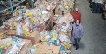  ?? KRIS DUBE THE WELLAND TRIBUNE ?? Bryon Pettit and Melissa Kirkpatric­k from Open Arms Mission with food the organizati­on received from Saturday’s Welland food drive.