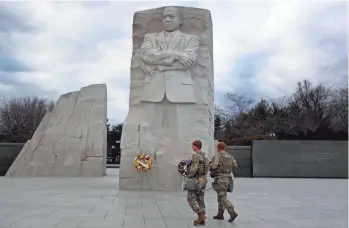  ?? JOE RAEDLE/GETTY IMAGES ?? Top: Florida National Guard members walk past the Martin Luther King Jr. Memorial in Washington, D.C., on Sunday. King’s legacy is perhaps more relevant than ever this year after a summer filled with protests demanding racial justice across the nation.