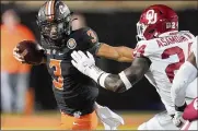  ?? SUE OGROCKI / AP ?? Oklahoma State quarterbac­k Spencer Sanders (3) carries the ball past Oklahoma linebacker Brian Asamoah (24) during the second half the Cowboys 37-33 win over the Sooners Saturday in Stillwater, Okla.