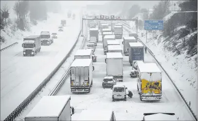  ?? Robert Michael The Associated Press ?? Cars and trucks are stuck in a traffic jam Monday in snowfall on the Autobahn 4 near Dresden.