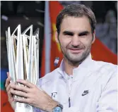  ??  ?? Roger Federer pose avec le trophée de champion du Masters de Shanghai. Associated Press: Andy Wong