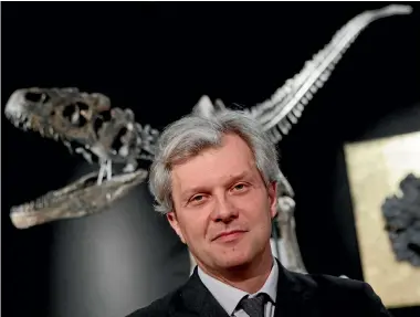  ?? PHOTOS: AP ?? Drouot auction house president Alexandre Giquello poses with a Jurassic period (161-145 million years ago) dinosaur skeleton of an Allosaurus jimmadseni.