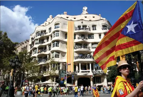  ??  ?? A La Pedrera in Barcelona, designed by Antoni Gaudi, is decorated with a Catalonian flag during a demonstrat­ion yesterday marking Catalan National Day.