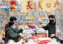  ?? JONATHAN HAYWARD THE CANADIAN PRESS ?? People shop in Vancouver’s Chinatown. Chinese-Canadian folks and businesses are facing racism in the pandemic, leaders say.