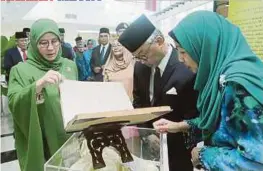  ??  ?? TENGKU Abdullah (tengah) dan Tunku Azizah Aminah Maimunah (kiri) meninjau ruangan pameran selepas merasmikan bangunan Perpustaka­an Awam Pahang.