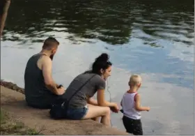  ?? MICHILEA PATTERSON — FOR MEDIANEWS GROUP ?? A family sits alongside the Schuylkill River during a Sustainabi­lity Fair in Royersford.