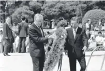  ?? Katsumi Kasahara, Associated Press file ?? Former President Jimmy Carter carries a wreath to place at the memorial cenotaph, a monument that contains the names of those who died in the 1945 atomic bombing of Hiroshima, Japan, on May 25, 1984. With him is then-Hiroshima Mayor Takeshi Araki.