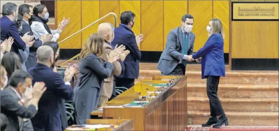  ?? / JULIO MUÑOZ (EFE) ?? El presidente andaluz, Juan Manuel Moreno, felicitaba a la consejera de Fomento, Marifrán Carazo, ayer en el Parlamento.