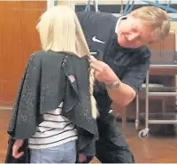  ??  ?? Hairdresse­r David Gosling cuts Isabella’s hair in front of her schoolmate­s