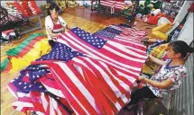  ?? JUN MING / FOR CHINA DAILY ?? Workers make national flags at a plant in Fuyang, Anhui province.