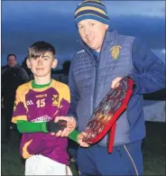  ?? ?? St Catherine’s captain Shay Wallace receiving the trophy following St Catherines U14 hurling tournament final success for the Tim O’Shea cup played in Carrigtwoh­ill recently.