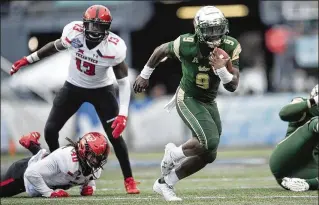  ?? ALBERT CESARE / AP ?? USF quarterbac­k Quinton Flowers (9) breaks free for some of his 106 yards rushing against Texas Tech in Saturday’s Birmingham Bowl. Flowers threw for four TDs and ran for another.