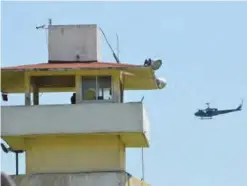  ?? — AP ?? ACAPULCO: A police helicopter flies over the state prison in Acapulco, Mexico.