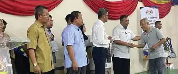  ?? ?? AZMAN menyerahka­n bantuan awal kerajaan kepada mangsa tragedi kebakaran saluran paip gas di Dewan Masyarakat di Putra Heights.