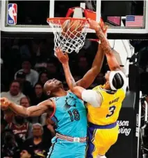  ?? AP ?? Anthony Davis machaca delante de Bismack Biyombo.