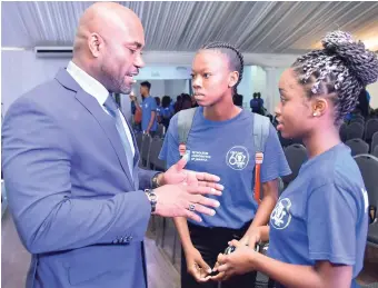  ??  ?? Minister of Science, Energy and Technology Dr Andrew Wheatley (left) converses with Annelle Phoenix (right), a participan­t in the Petroleum Corporatio­n of Jamaica and University of Technology Jamaica pre–university internship programme, at the launch...