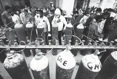  ?? (AFP) ?? OXYGEN REFILL - People refill medical oxygen cylinders for COVID-19 patients at an oxygen refill station in Allahabad on April 20, 2021.