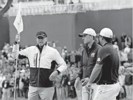  ?? [AP FILE PHOTO] ?? United States vice-captain Steve Stricker holds a flag for United States’ Jordan Spieth and Patrick Reed during a practice round for the Ryder Cup golf matches on Sept. 28, 2016, at Hazeltine National Golf Club in Chaska, Minn.