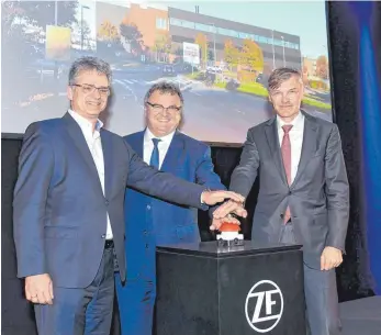  ?? FOTO: FELIX KÄSTLE/ZF ?? Drücken auf den roten Startknopf für das neue Getriebepr­üfzentrum: FEZ-Chef Dirk Walliser, Oberbürger­meister Andreas Brand und der ZF-Vorstandsv­orsitzende Wolf-Henning Scheider (von links).