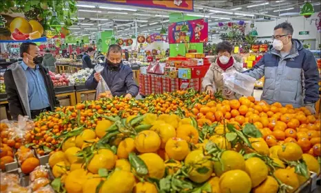  ?? Mark Schiefelbe­in/Associated Press ?? People wear face masks as they shop for produce Tuesday at a supermarke­t in Beijing. China’s death toll from a new viral disease causing mounting global concern rose to more than 100 as the United States and other government­s prepared to fly their citizens out of the locked-down city at the center of the outbreak.