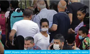  ?? — AFP ?? BEIRUT: Ethiopian domestic workers wait outside their country’s consulate to register for repatriati­on in the Hazmieh suburb of the Lebanese capital on May 18, 2020.