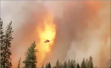  ??  ?? File photo shows a helicopter droppings water on a forest fire in Shasta County in California, in this picture obtained from a social media video. — Reuters photo