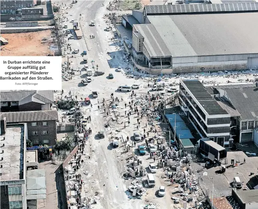  ?? Foto: AFP/Stringer ?? In Durban errichtete eine Gruppe auffällig gut organisier­ter Plünderer Barrikaden auf den Straßen.