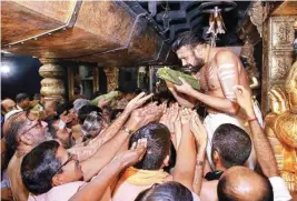  ??  ?? Head priest Kandararu Rajeevarau gives ‘prasad’ to devotees at Sabarimala temple on Sunday PTI