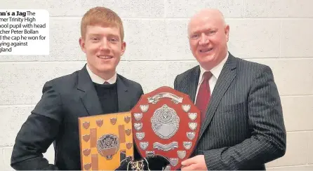  ??  ?? John’s a JagThe former Trinity High School pupil with head teacher Peter Bollan and the cap he won for playing against England