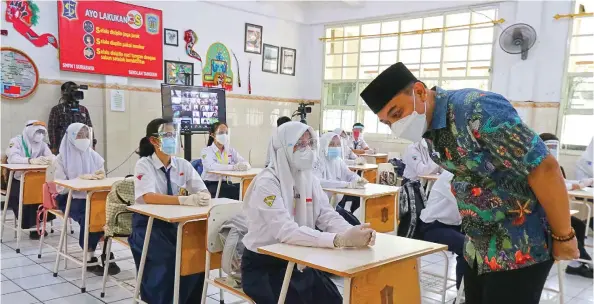  ?? FRIZAL/JAWA POS ?? SINAU BARENG PAK WALI: Wali Kota Surabaya
Eri Cahyadi memberikan motivasi pada simulasi sekolah tatap muka di SMPN 1 Surabaya. Rencananya, PTM berlangsun­g pada Juli.