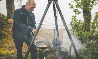  ?? NANNA HEITMANN/FOR THE WASHINGTON POST ?? Ingemar Lestander fries Arctic char over a fire in Arjeplog.